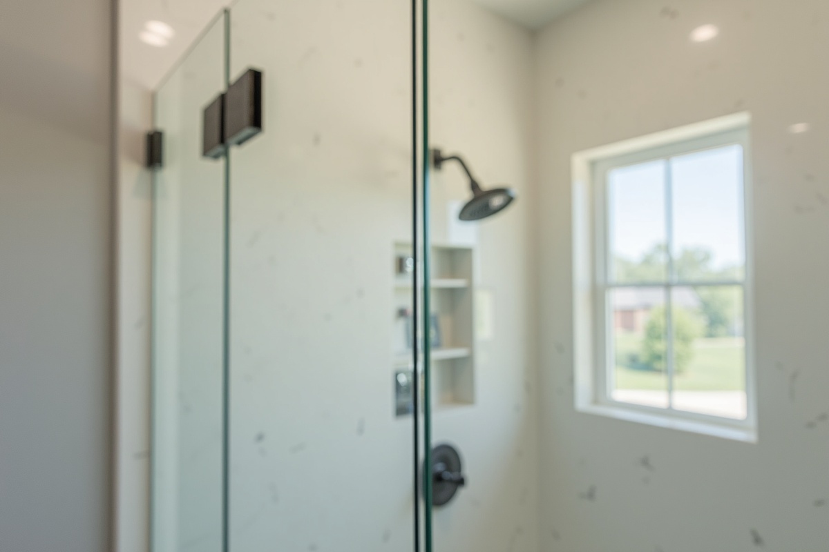 Frameless shower door installation in a Richardson TX home showing glass panel being positioned on wall-mounted European hinges with clear tempered glass