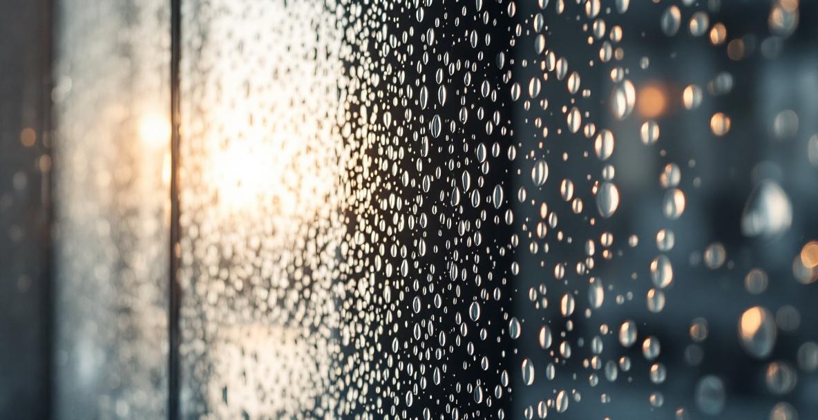Close-up of textured patterned glass shower door panel showing decorative surface pattern that provides privacy while adding visual interest to a bathroom