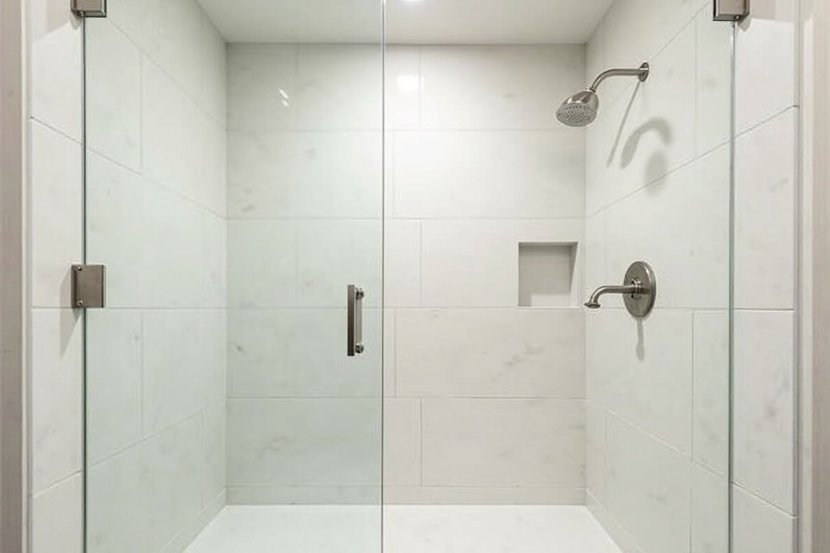 Completed frameless shower enclosure in Keller TX home with brushed nickel hardware showing the clean aesthetic of a fully frameless installation
