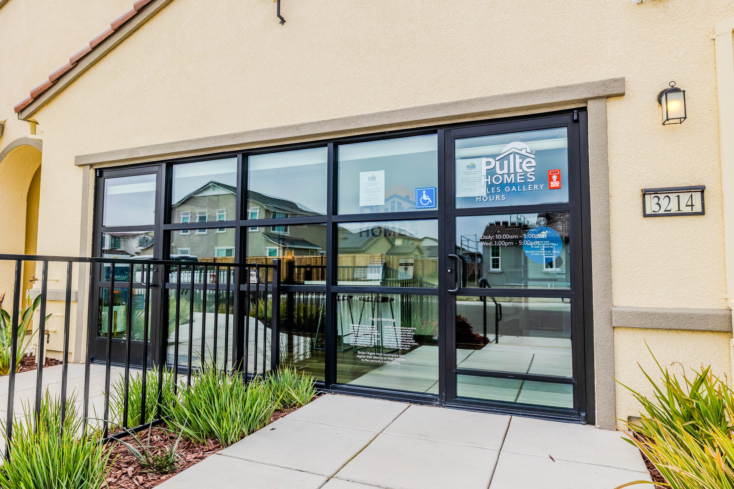 Black-framed glass office partitions with blue-tinted privacy glass forming individual workspace suites — an Infinity Glass & Glazing installation